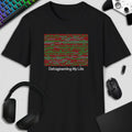 Black t-shirt with a colorful square design and 'Defragmenting My Life' text, surrounded by computer accessories on a light gray background.